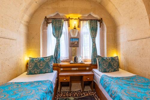 a small room with two beds and a table at Walnut House in Goreme
