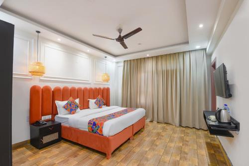 a bedroom with a large bed and a television at White Pepper in Faridabad