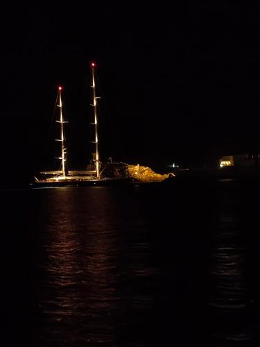 a sail boat in the water at night at Korina's Suites in Andros