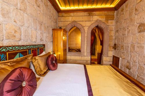 a bedroom with a bed in a stone wall at Walnut House in Goreme