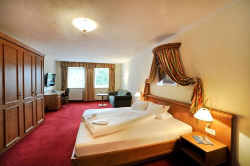a hotel room with a large bed and a desk at Vital Hotel Ortlerspitz in San Valentino alla Muta