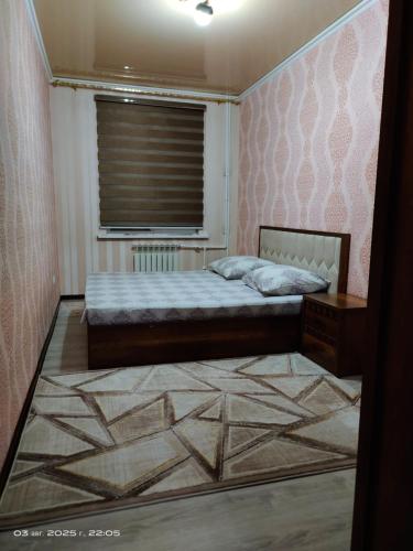 Un dormitorio pequeño con una cama y una ventana. en ЮнусАбад, en Yunusobod