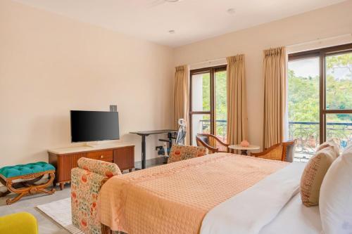 a bedroom with a bed and a tv at Casa Suneos 4-BHK Villa With Private Pool & Lift Near Popular Restaurants in Siolim