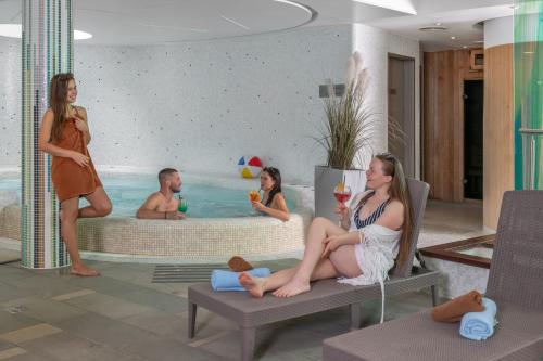 a group of people sitting in a swimming pool at Jankovich Hotel in Rácalmás