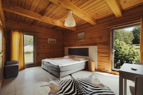 a bedroom with a bed in a wooden cabin at Obrocz137 in Obrocz