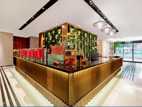 a lobby with a counter with a lot of bottles at Jinjiang Metropolo Wuyishan Sangu Resort Hotel in Wuyishan