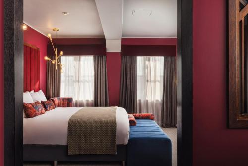 a hotel room with a bed and red walls at Malmaison Newcastle in Newcastle upon Tyne