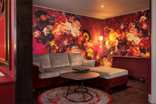 a living room with a couch and a colorful wall at Malmaison Newcastle in Newcastle upon Tyne