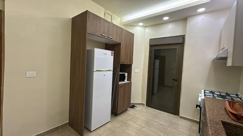 a kitchen with a white refrigerator in a room at Akl - Chic Apartments & Balconies in Batroun in Batroûn
