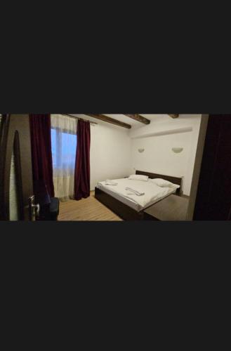 a small bedroom with a bed and a window at Hotel Bran Dracula in Bran