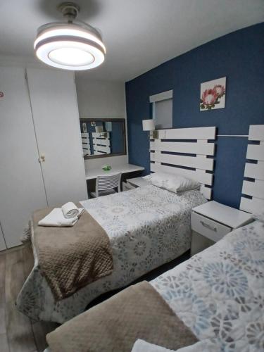 a bedroom with two beds and a desk in it at Arrowood 2 in Plettenberg Bay