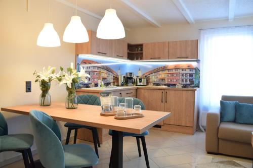 a kitchen with a wooden table and blue chairs at Hotel Garni " Am Domplatz" in Erfurt
