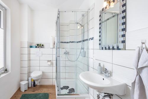 a white bathroom with a sink and a toilet at Tiny Home in Lübeck