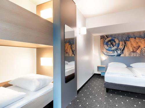 two beds in a small room with two beds sidx sidx sidx sidx at B&B Hotel Emden in Emden