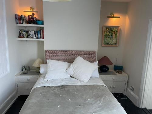 a bedroom with a bed with white pillows at Colourful 2 bed 2 bath Tooting house in London