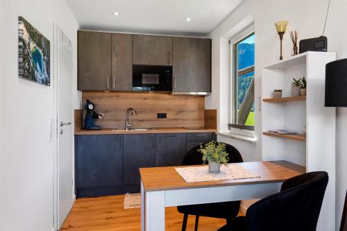 a kitchen with a wooden table and a sink at Ferienwohnung Sophia Inzell - Neu in Inzell