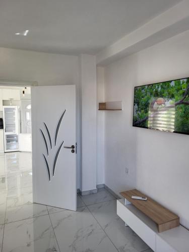a white door in a room with a television on a wall at Jordanovi Premium Apartment in Kavadarci