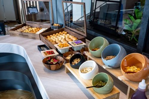 a buffet with bowls of food on a table at ANA Holiday Inn Iwate Kitakami by IHG in Kitakami