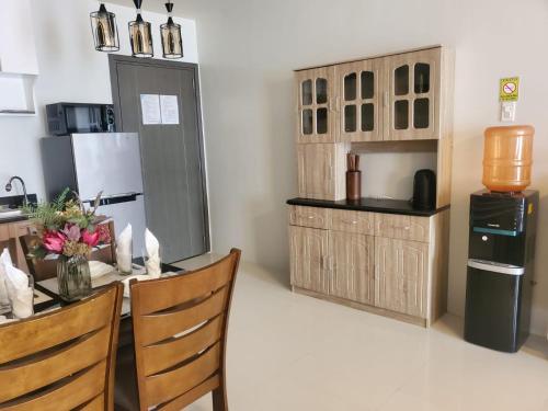 a kitchen with a table and chairs and a refrigerator at VERDANT by Vista Manors Deluxe Rooms with Balcony, Gym and Swimming Pool in Puerto Princesa City