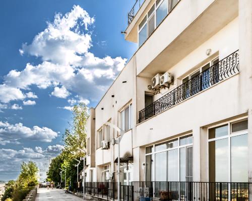 a white building with balconies on a street at ElStefanino House in Eforie Nord