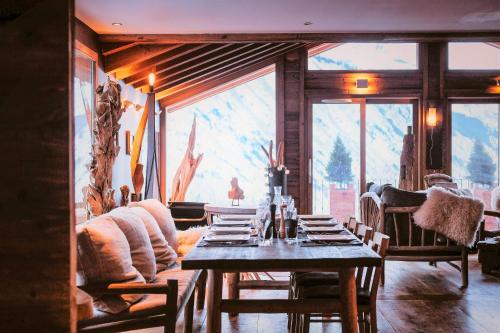 a dining room with a table and a large window at Le Chalet St Martin 10 pers, 5 chambres, avec sauna, piscine in Saint-Martin-de-Belleville