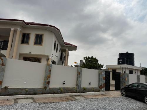 a white fence in front of a house at OB DELUXE Apartments 3 in Accra