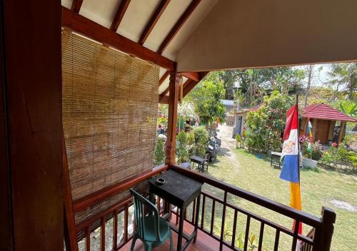 a balcony of a house with a table and a flag at Herman Pondok Nyodok in Pawenang