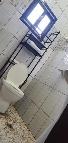 a bathroom with a toilet and a window at Air-conditioned apartment, secured Residence Kribi in Kribi