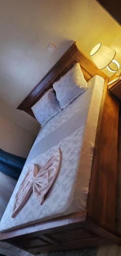 a bed with a wooden headboard and pillows at Air-conditioned apartment, secured Residence Kribi in Kribi