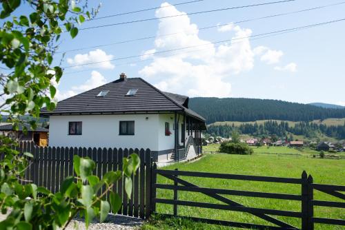 a white house with a fence and a field at Mera House Bilbor in Bilbor