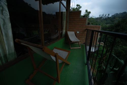 a balcony with two chairs and a swing at Ayubo Ella - Bed & Breakfast in Ella