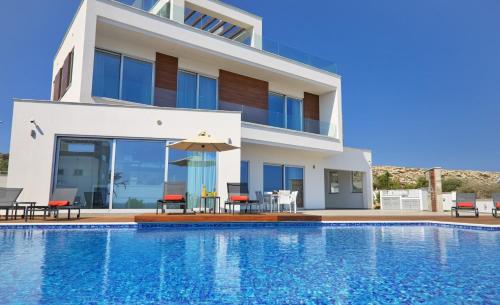 a villa with a swimming pool in front of a house at Sea Pearl Seaview Villa - Oriana in Ayia Napa