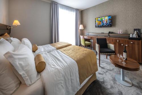 a hotel room with a large bed and a desk at Jankovich Hotel in Rácalmás