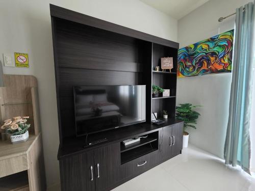 a large entertainment center with a television in a room at VERDANT by Vista Manors Deluxe Rooms with Balcony, Gym and Swimming Pool in Puerto Princesa City