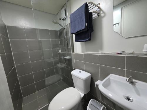 a bathroom with a white toilet and a sink at VERDANT by Vista Manors Deluxe Rooms with Balcony, Gym and Swimming Pool in Puerto Princesa City