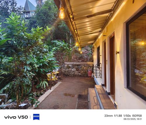 a porch of a house with awning and a pathway at CLOUD HUG'S COUPLES STAY Rooms Vagamon in Vagamon