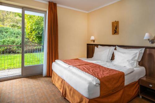 a hotel room with a bed and a large window at Jankovich Hotel in Rácalmás