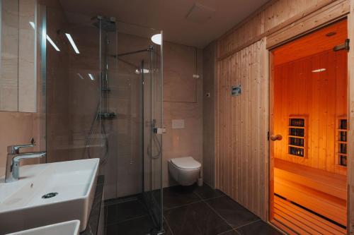 a bathroom with a shower and a sink and a toilet at MOLO LIPNO RESIDENCE in Lipno nad Vltavou