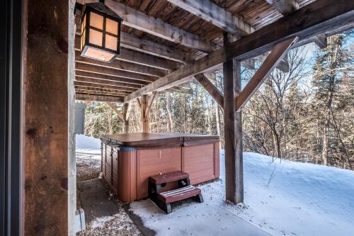 a wooden house with a stove in the snow at RCNT Chalets Mont-Tremblant in Lac-Superieur