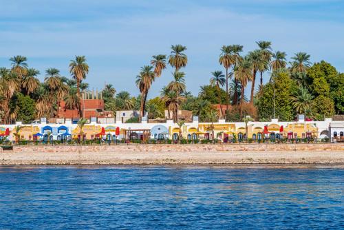 a group of colorful buildings and palm trees on the beach at Sonesta Nouba Hotel Aswan in Aswan
