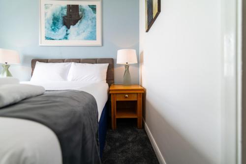 a bedroom with two beds and a night stand with two lamps at The Southcliff Hotel in Folkestone
