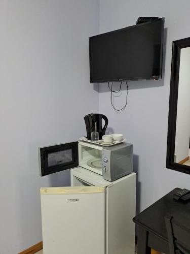 a television on a wall above a refrigerator at Palmetto guesthouse in Mahikeng
