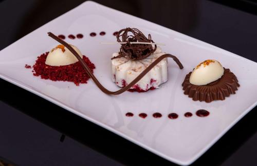 three desserts on a white plate on a table at Sonesta Nouba Hotel Aswan in Aswan