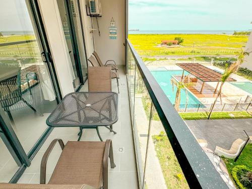 einen Balkon mit Stühlen und Poolblick in der Unterkunft Apartamento Salinas del Mar - balcon y vista al mar - By Bedviajes in Playa Bello Horizonte