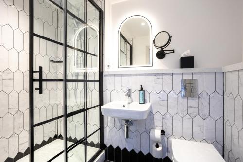 a bathroom with a sink and a mirror at The Met Hotel Leeds - Newly Refurbished in Leeds