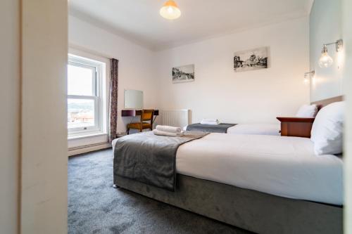 a bedroom with two beds and a window at The Southcliff Hotel in Folkestone