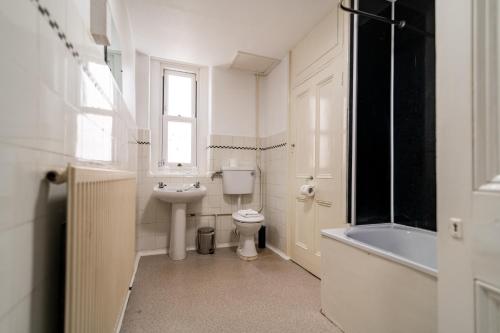 a white bathroom with a toilet and a sink at The Southcliff Hotel in Folkestone