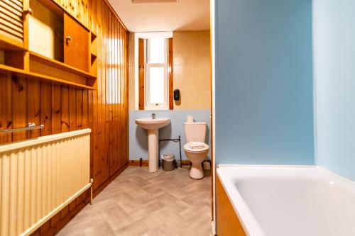 a bathroom with a tub and a toilet and a sink at The Southcliff Hotel in Folkestone