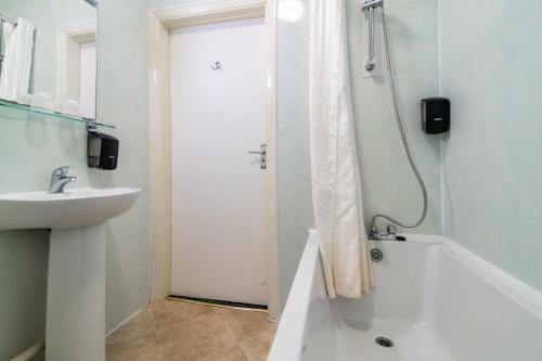 a white bathroom with a shower and a sink at The Southcliff Hotel in Folkestone