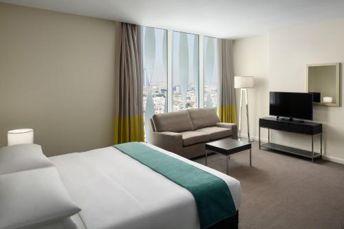 a hotel room with a bed and a chair at Staybridge Suites Al Khobar by IHG in Al Khobar